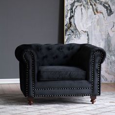 a black chair sitting in front of a painting