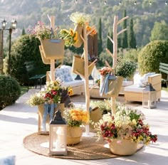 an outdoor area with flowers and plants in baskets on the ground, along with lights