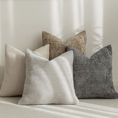 four pillows sitting on top of a white couch