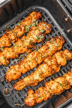 chicken skewers are being cooked on the grill with parmesan cheese and herbs