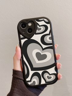 a person holding up a cell phone case with hearts on it