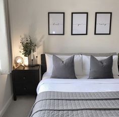 a bed with two framed pictures on the wall above it