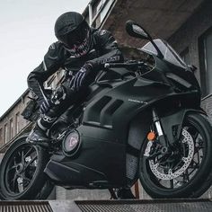 a man riding on the back of a black motorcycle