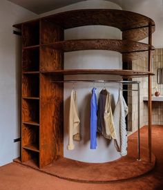 a wooden shelf with clothes hanging on it