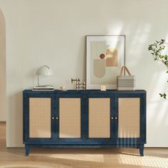 a blue cabinet with wicker doors in a living room next to a potted plant