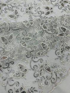 an embroidered fabric with silver sequins on it