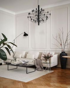 a living room filled with furniture and a chandelier hanging over the top of it