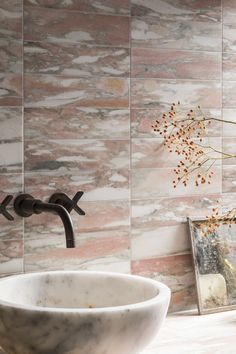 a bathroom sink sitting under a faucet in front of a wall mounted mirror