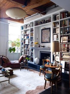 a living room filled with furniture and bookshelves next to a fire place in front of a fireplace