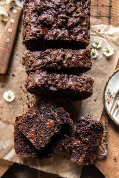 chocolate brownies are stacked on top of each other next to a knife and fork