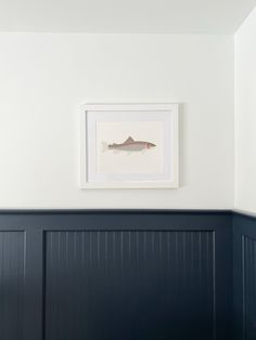 a fish is mounted on the wall above a bed in a room with blue paneling