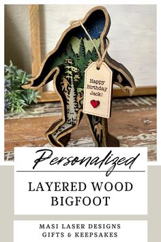 a paper cut out of a bear holding a tag that says, personalized layered wood bigfoot