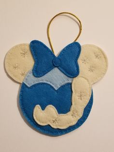 a blue and white mickey mouse ornament hanging from a gold keychain