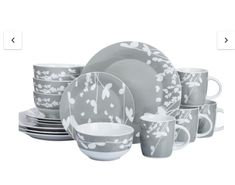 a gray and white dinnerware set with flowers on it