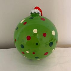 a green christmas ornament with red and white polka dots