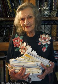 an older woman holding stacks of mail in her hands