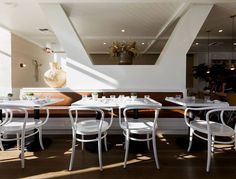 an empty restaurant with white tables and chairs