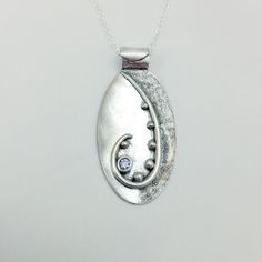 This beautiful pendant is completely hand-crafted from precious metal clay (Art Clay Silver). Every pendant from my studio is unique because each is crafted using textures created by me--not molds or stamps. No two will even be identical and you will never see anyone else wearing an identical piece. The pendant measures 1-3/4 inch long and 7/8 inch wide and is finished with a dark patina. It features a lavender color cubic zirconia It comes complete with an 18 or 20-inch sterling silver oval cable chain so it is ready to wear from moment you receive it, and is packaged in a box suitable for gift giving. This item will ship within 1-3 days. It will ship USPS Priority. Handmade Oval Pendant Necklace In Sterling Silver, Unique Oval Pendant Jewelry With Oxidized Finish, Artistic Handmade Oval Pendant Necklace, Silver Clay Pendant, Silver Polymer Clay Pendant Necklace, Metal Clay Art, Art Clay Silver, Metal Clay Jewelry, Precious Metal Clay