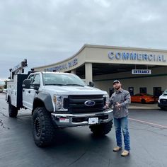 a man standing next to a truck in front of a commercial building