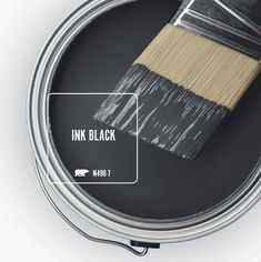 a paint can with a brush in it and the words ink black on top of it