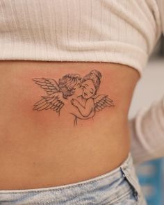 a woman's stomach with an angel tattoo on it