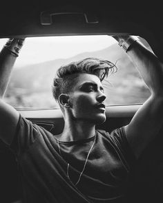 a woman sitting in the back seat of a car with her headphones hanging out