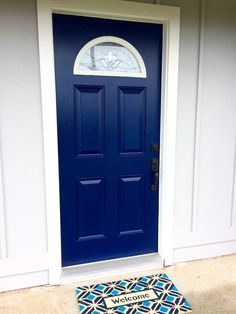 a blue door with a welcome mat in front of it