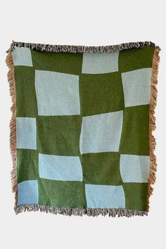 a green and blue checkered blanket with fringes