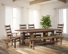 a dining room table with chairs and a bench in front of it on a wooden floor