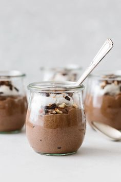 three jars filled with chocolate pudding and topped with whipped cream