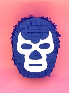 a blue and white mask on a pink background