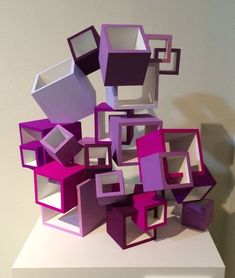 purple and white cubes stacked on top of each other in the middle of a room