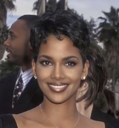 a close up of a person in a suit and tie with other people behind her