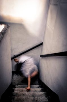 a person climbing up some stairs with their feet on the ground and one hand in the air