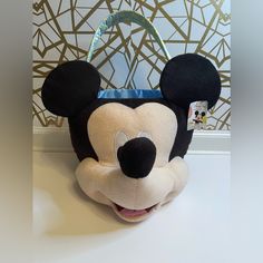 a stuffed mickey mouse head sitting on top of a white table next to a wall