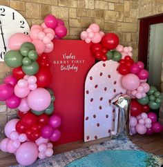 a bunch of balloons that are in front of a wall with a clock on it