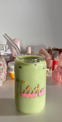 a jar filled with green liquid sitting on top of a white table next to other items