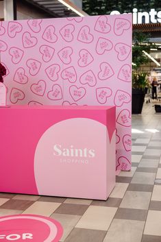 a pink box with hearts on it sitting in the middle of a checkered floor