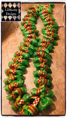 there are many green and red candys on the floor with ribbons around them that look like they have been wrapped in plastic