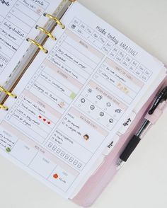 an open planner with a pen on top of it