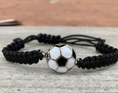 a black and white bracelet with a soccer ball on it