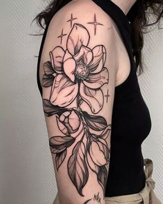 a black and white flower tattoo on the arm