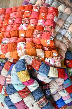 a pile of baby clothes sitting on top of a wooden floor