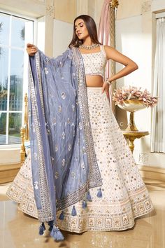 White/Powder Blue Designer Lehenga Choli With Elegant Work Elegance and honorable come together in this beautiful drape. White designer lehenga choli from palkhi fashion. Pure georgette lehenga and matching blouse assembled with petite sequin embroidery, threads, stones, and appealing handwork. This attire comes with a powder blue full-length pure georgette dupatta enriched by thread embroidery, sequins, and beautiful threadwork followed by attractive designs, which add extra charm. Blue Designer Lehenga, White Lehenga Choli, Orang India, White Lehenga, Georgette Lehenga