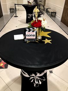 a black table with flowers and decorations on it in a room that has white tile flooring