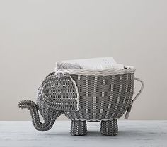 an elephant shaped basket sitting on top of a wooden table next to a white wall