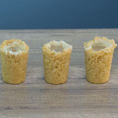 three small cupcakes sitting on top of a wooden table