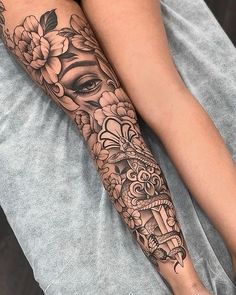 a woman's leg with tattoos and flowers on it