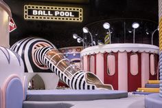 an indoor play area with various toys and lights on the ceiling, including a ball pool slide