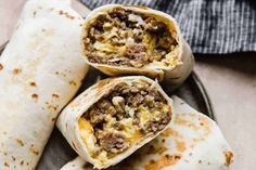 three burritos on a plate with meat and cheese in the middle, ready to be eaten